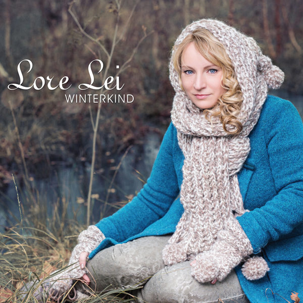 CD Cover LoreLei Winterkind - Lore Lei sitzend im blauen Wintermantel mit gestricktem Kapuzenschal